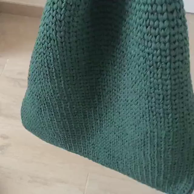 storing toys in a deep green hanging basket